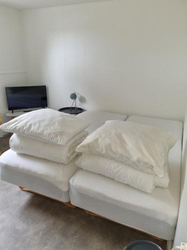 维泽桑讷Feriehuse Hvide Sande的客房内床上的白色枕头堆