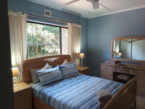 圣卢西亚Turtleshaven的一间卧室配有一张带镜子的床和窗户