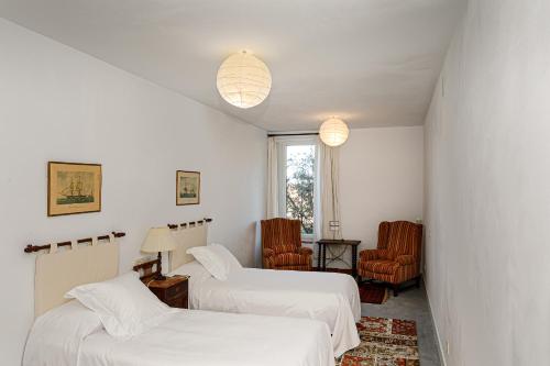 塞哥维亚Hotel Rural Costa del Trigo的一间客房配有两张床和两把椅子