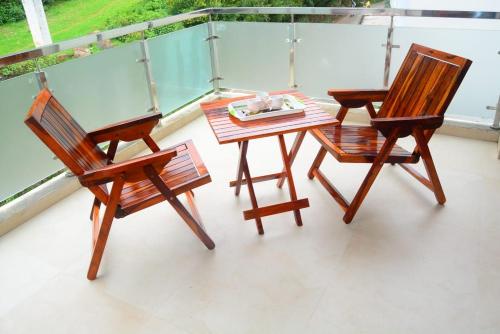 乌提Vanam Holidays Inn的阳台配有2把椅子和1张桌子