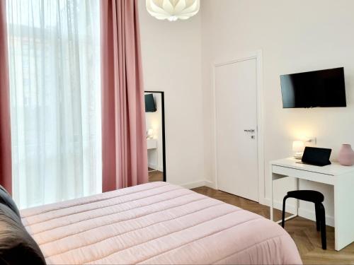 卡利亚里Glamour Suite Cagliari的一间卧室配有一张床、一张书桌和一台电视