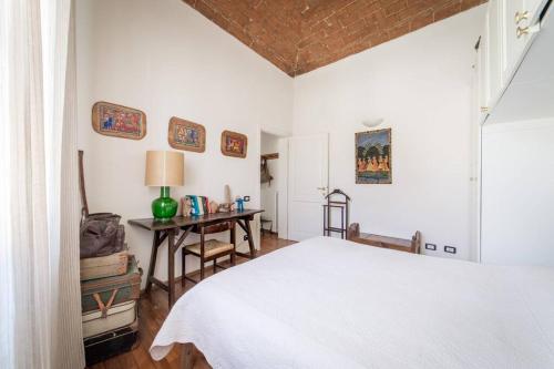 普拉托Lovely apartment in Tuscany, near Florence的卧室配有白色的床和书桌