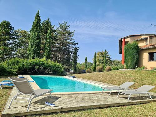 Lamothe-CapdevilleChambres d hotes, la maison de Kat的一个带两把椅子的游泳池以及一座房子