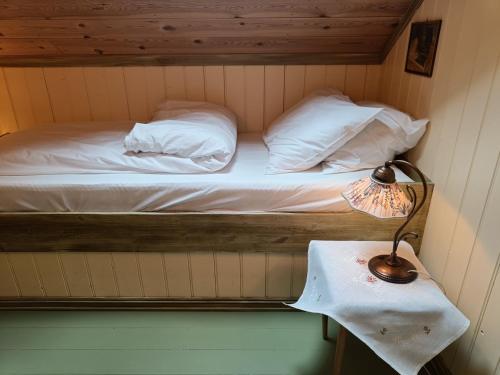 OrheimOrheimstunet - Gårdsferie for storfamilien der også hunden er velkommen的一张床上的房间,桌子上有一盏灯