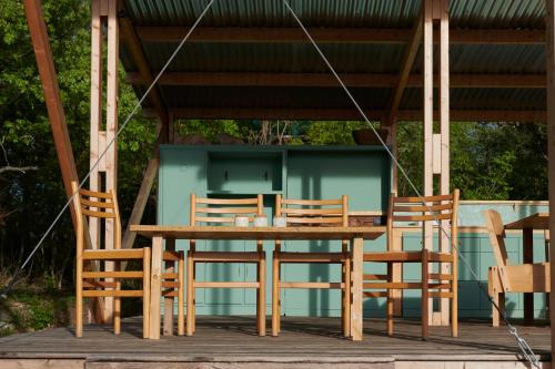 拉亚蒂科Agricola Ombra - Tents in nature的凉亭下的木桌和椅子