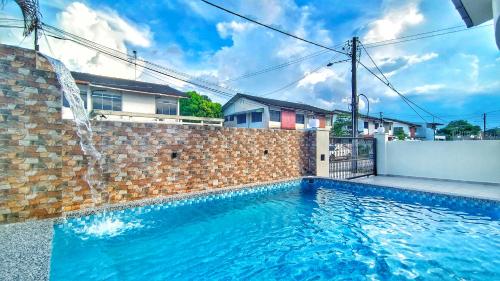 新山JB City Villa (Private Pool)的砖墙前的游泳池