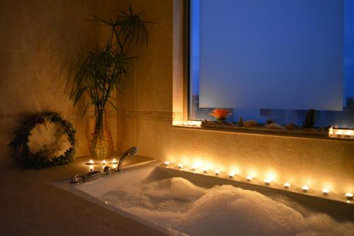 阿斯格罗Home21的一间带镜子和灯的浴缸的浴室