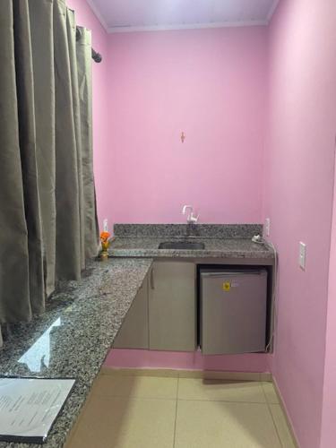 阿莱格雷特Pousada Mercosul的一间带水槽和粉红色墙壁的浴室