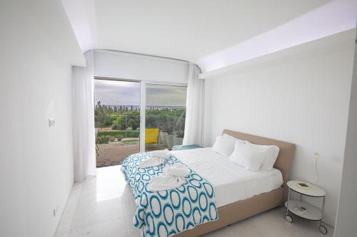 普罗塔拉斯Thalassa Luxury Apartment的白色的卧室设有床和大窗户