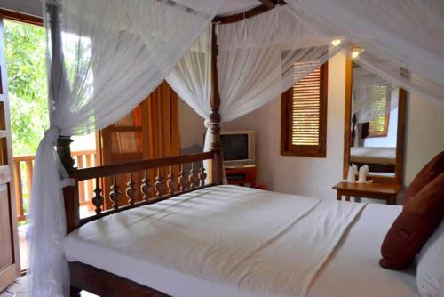 贝里胡罗亚兰达度假酒店的一间卧室配有一张带天蓬的白色床