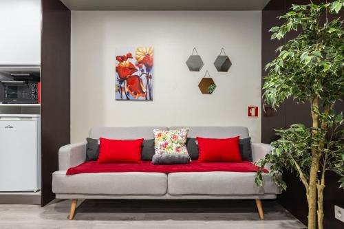 加亚新城Hopstays - Gaia Cork House的客厅里一张带红色靠垫的沙发