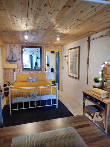 卡林福德The Old Boat House的一间卧室设有一张木天花板床。
