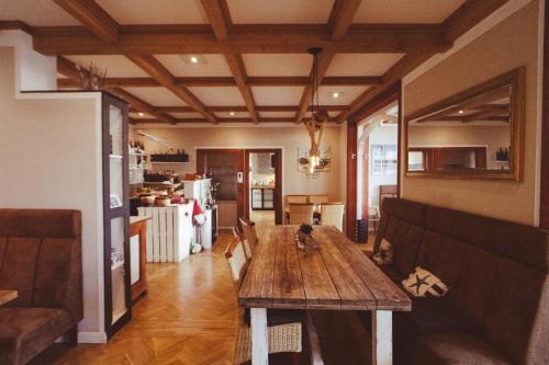 宾茨Hotel Villa Schwanebeck的一间带木桌的客厅和一间厨房