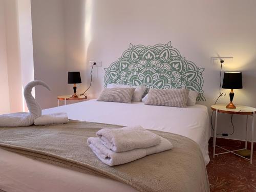 大加那利岛拉斯帕尔马斯Doranda Rooms Las Canteras的卧室配有带毛巾的大型白色床