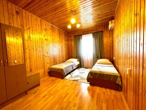 加格拉Дом под ключ Комфортик的配有木墙和木地板的客房中的两张床
