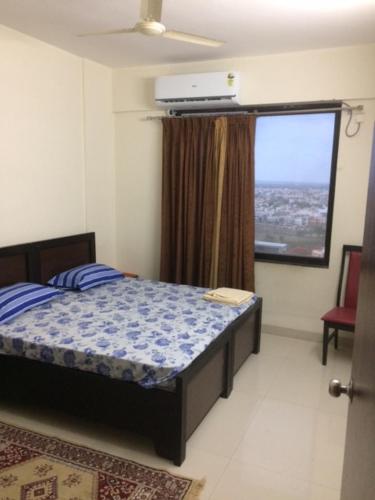 印多尔executive rooms @ indore-mp.的一间卧室设有一张床和一个大窗户