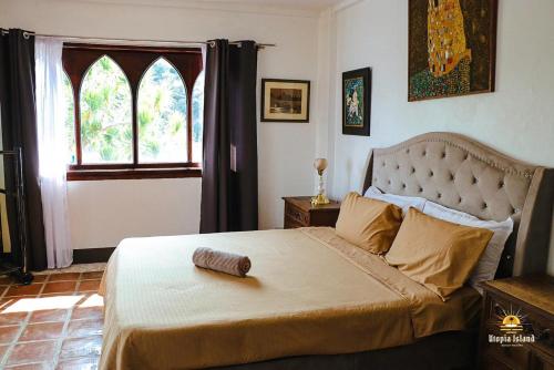 八打雁Utopia Island Resort的一间卧室设有一张大床和大窗户