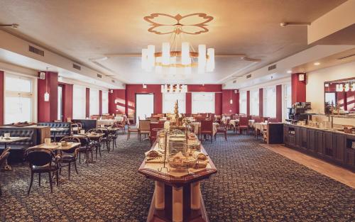 达沃斯Hotel Strela by Mountain Hotels的一间带桌椅和吊灯的用餐室