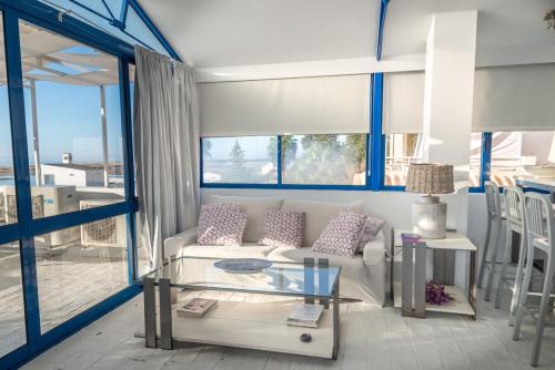 维拉诺瓦德卡塞拉Lightbooking Praia Fabrica Algarve的带沙发和玻璃桌的客厅