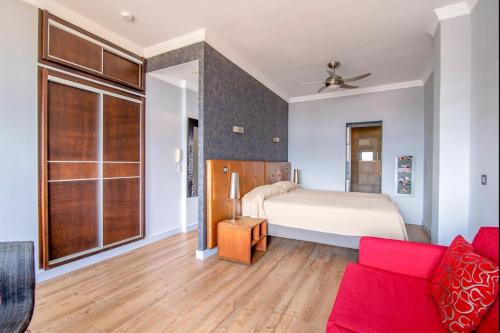 大加那利岛拉斯帕尔马斯Lightbooking Las Canteras Beach Sea View的一间卧室配有一张床和一张红色的沙发