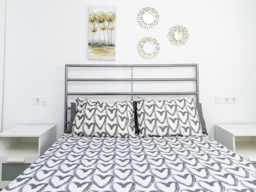 圣玛丽亚港Lightbooking Blanca Paloma Cádiz的卧室配有带枕头的黑白床。