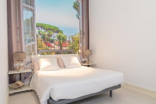 维拉诺瓦德卡塞拉Lightbooking Praia Fabrica Algarve的一间卧室设有一张床和一个大窗户