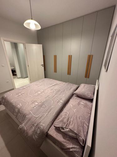 比雷埃夫斯A&A Apartment的一间卧室配有一张带粉红色床单的大床