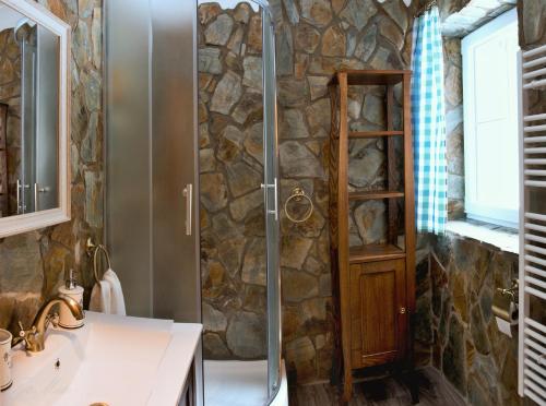 特尔乔夫Horský apartmán Vrátna-Saška的带淋浴的浴室(带石墙)