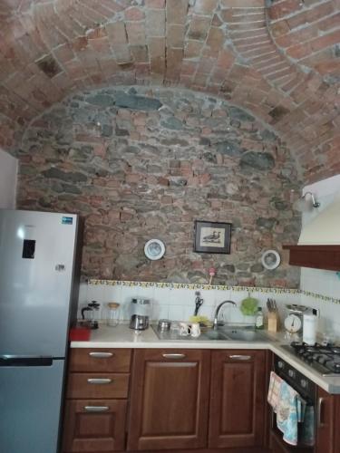 阿维利亚纳Antiche Mura的厨房设有石墙和冰箱。
