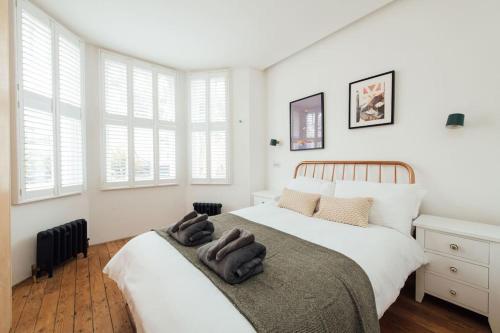 芬奇利Stylish 2 Bedroom Flat with a Private Sauna的卧室设有两张床,拥有白色的墙壁和窗户。