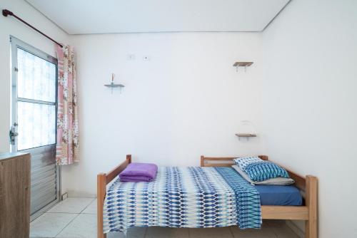 圣保罗Aconchego Azul Suítes Vila Mariana的一间卧室设有一张床和一个窗口