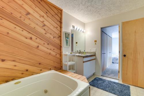 哈伯斯普林斯Trout Creek Resort Condo - 1 Mi to Nubs Nob!的带浴缸和木墙的浴室