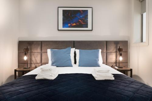 波尔图Invicta Premium - Downtown apartment的一间卧室配有一张床,上面有两条毛巾