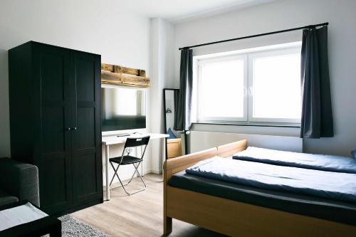 施内沃丁根Heide Ferienwohnung Süd的一间卧室配有一张床、一个窗口和一张书桌