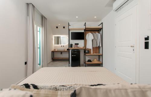 圣安娜纳克索斯Iades Studios & Apartments的一间白色卧室,配有床和厨房