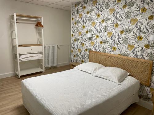 勒旺Hôtel La Vigneraie的一间卧室设有一张床和花卉墙
