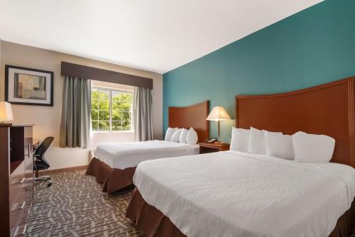 托皮卡SureStay Plus Hotel by Best Western Topeka的酒店客房设有两张床和窗户。