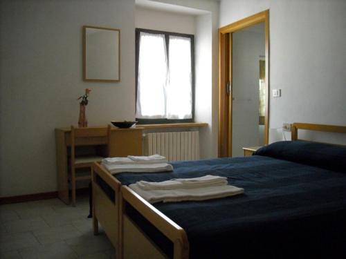 圣莱奥Affittacamere Arcobaleno的一间卧室配有一张带蓝色床单的床和一扇窗户。