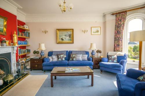 圣奥斯特尔Ivy House Cornwall B&B的客厅设有蓝色的沙发和壁炉