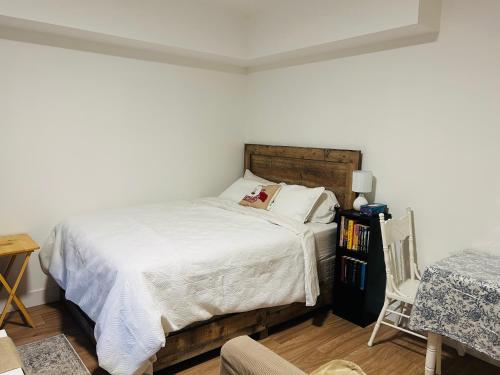 维多利亚Victoria private studio suite的一间卧室配有一张带白色床单和椅子的床