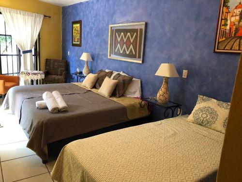 瓦哈卡市Suite Antequera en mexico的一间卧室设有两张床和蓝色的墙壁