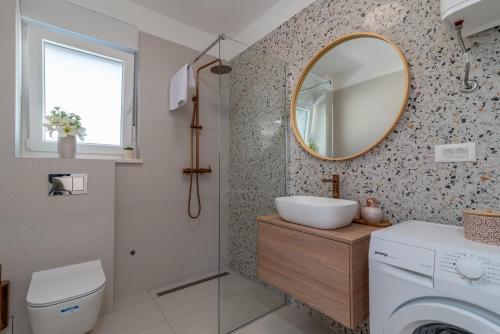 特罗吉尔Infinity Residence的浴室设有水槽和墙上的镜子