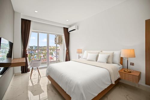 西哈努克MLZ Apartments Sihanoukville的卧室设有一张白色大床和一扇窗户。