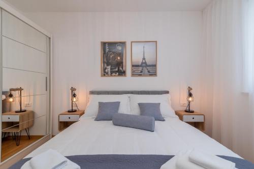 特罗吉尔Infinity Residence的卧室配有带蓝色枕头的大型白色床