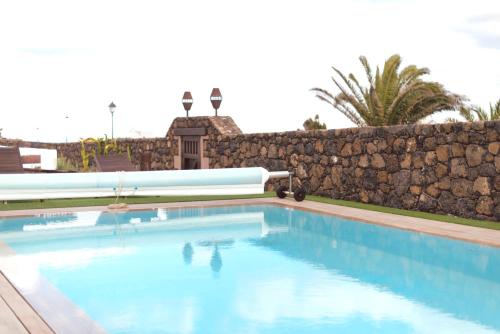 阿索马达Casa Serendipia的石头墙前的游泳池