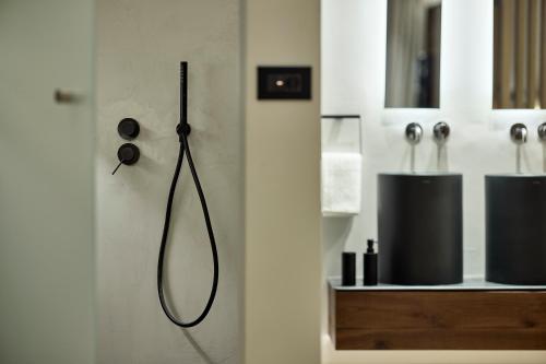 雅典Icon Suite的浴室的墙壁上设有黑色淋浴喷头