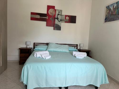 布林迪西Calamaterdomini a 2 passi dal mare的一间卧室配有蓝色的床和毛巾