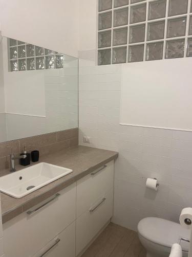 卡梅拉诺Alba - Le Grotte Rooms & Apartments的白色的浴室设有水槽和卫生间。