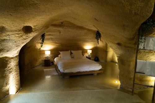 杜埃拉丰坦La falaise perdue : Suite troglodyte grandiose的洞穴内的卧室,里面设有一张床