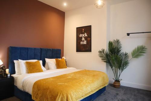 纳尔斯伯勒Berry's Retreat - Kist Accommodates的一间卧室配有一张带蓝色床头板和植物的床
